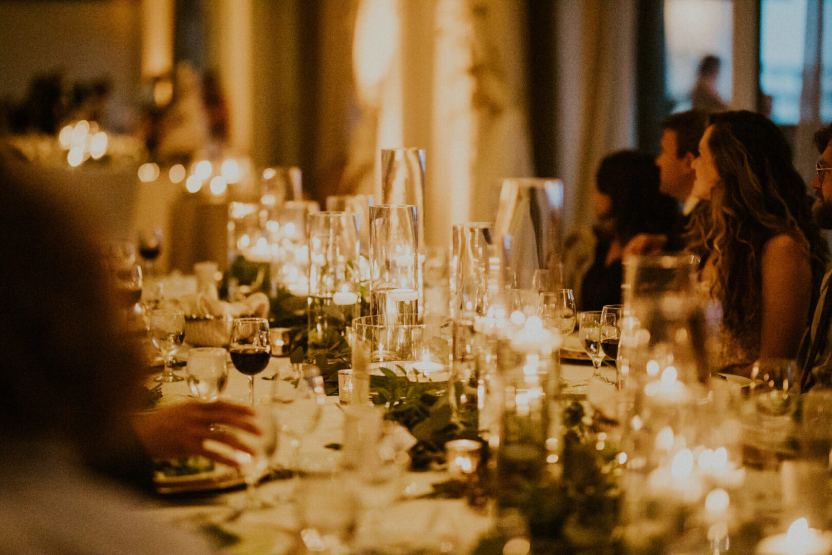 A table with many glasses of wine and candles