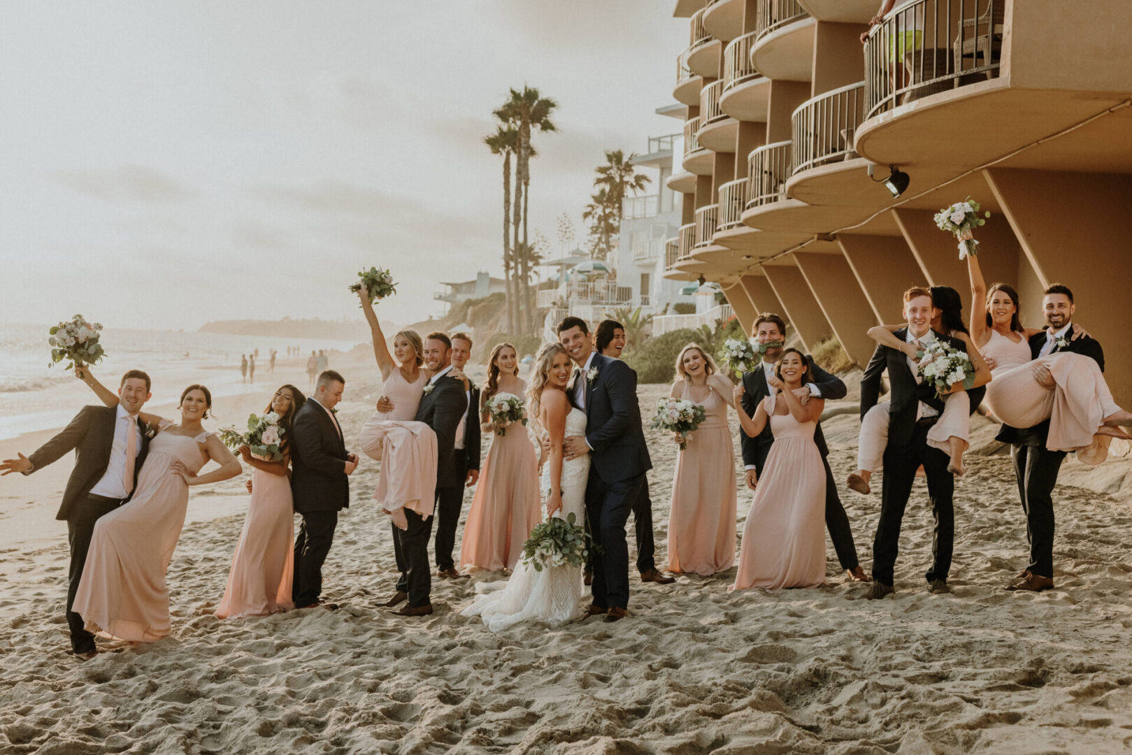 A group of people standing on top of a sandy beach.