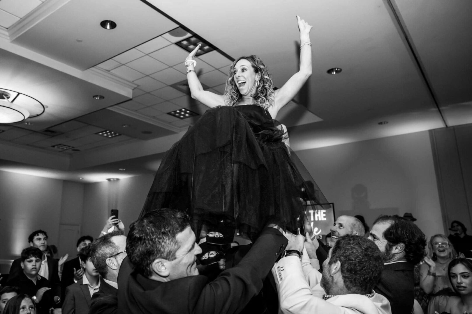 A woman is lifted up by people in the crowd.