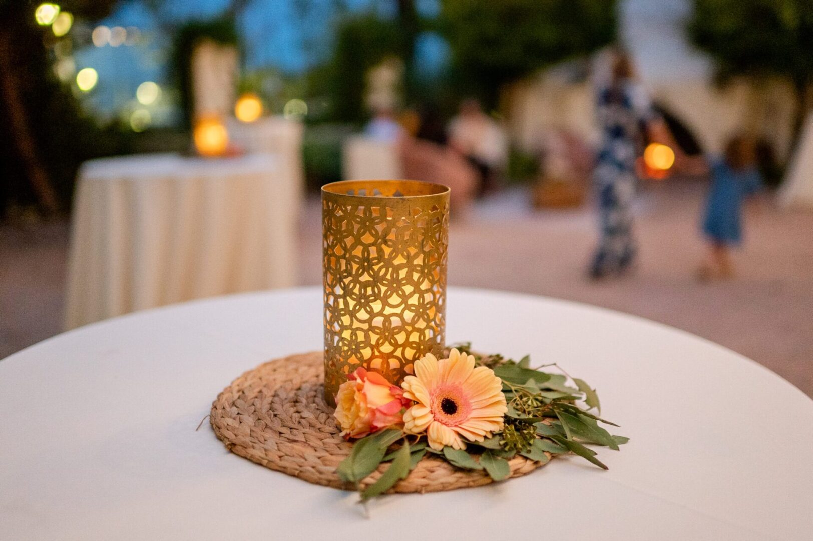 A candle holder with flowers on top of a table.