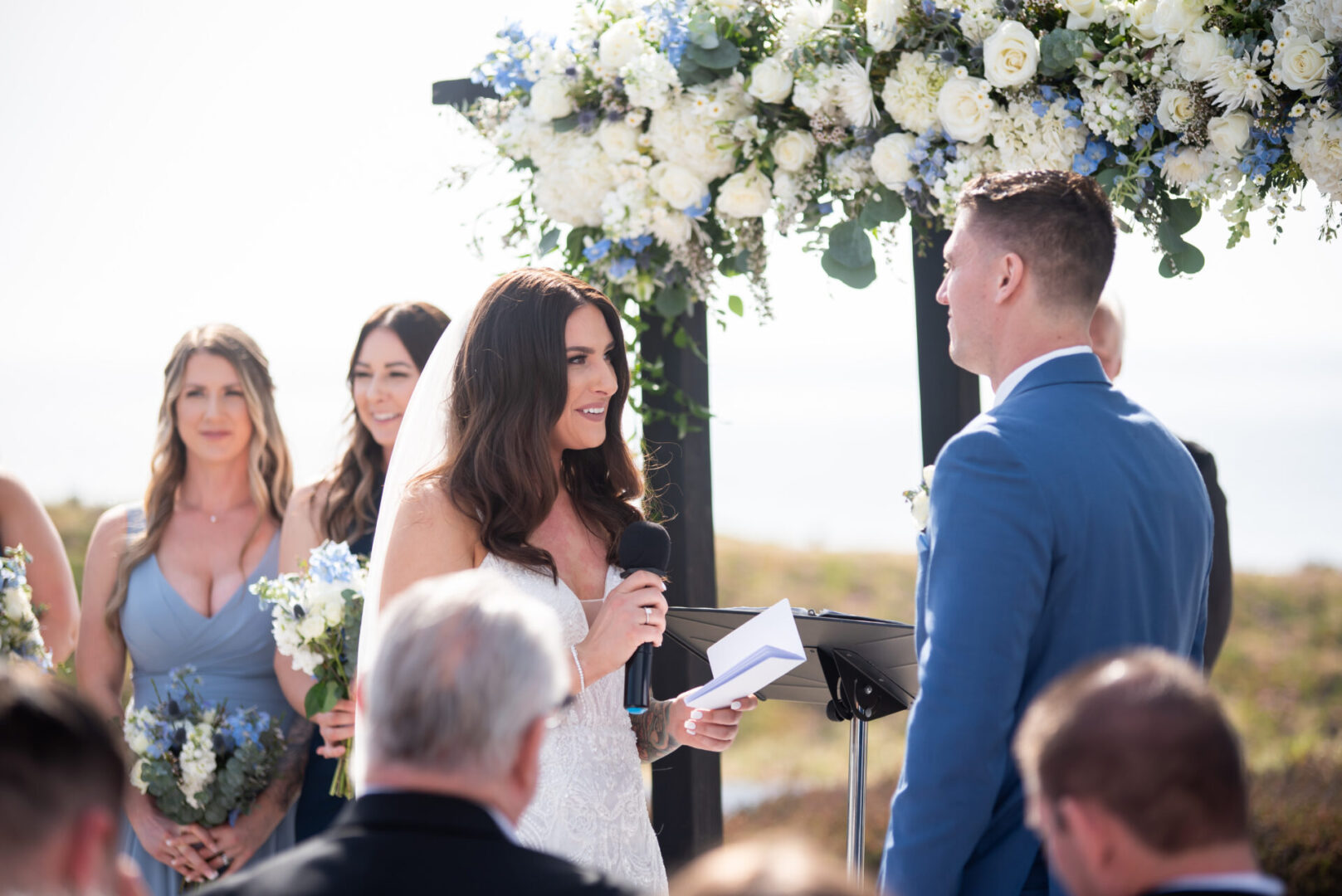 A bride and groom are standing under an arch.