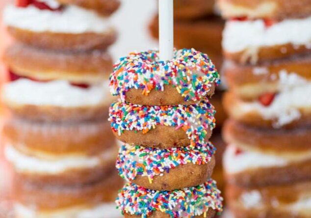 A stack of donuts with colorful sprinkles on top.