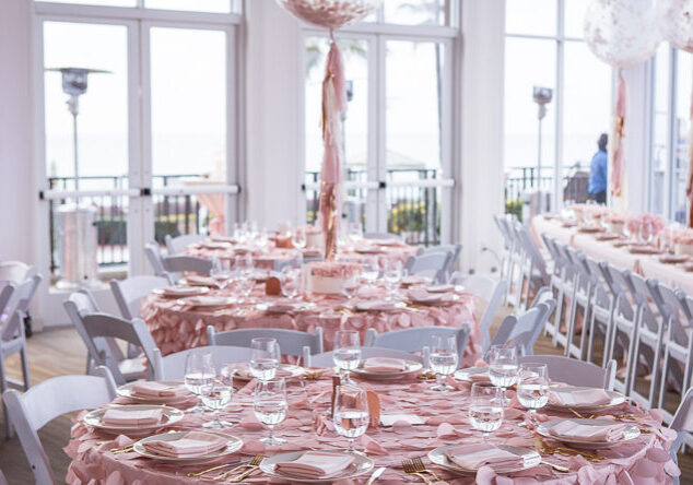 A table set up with pink plates and napkins